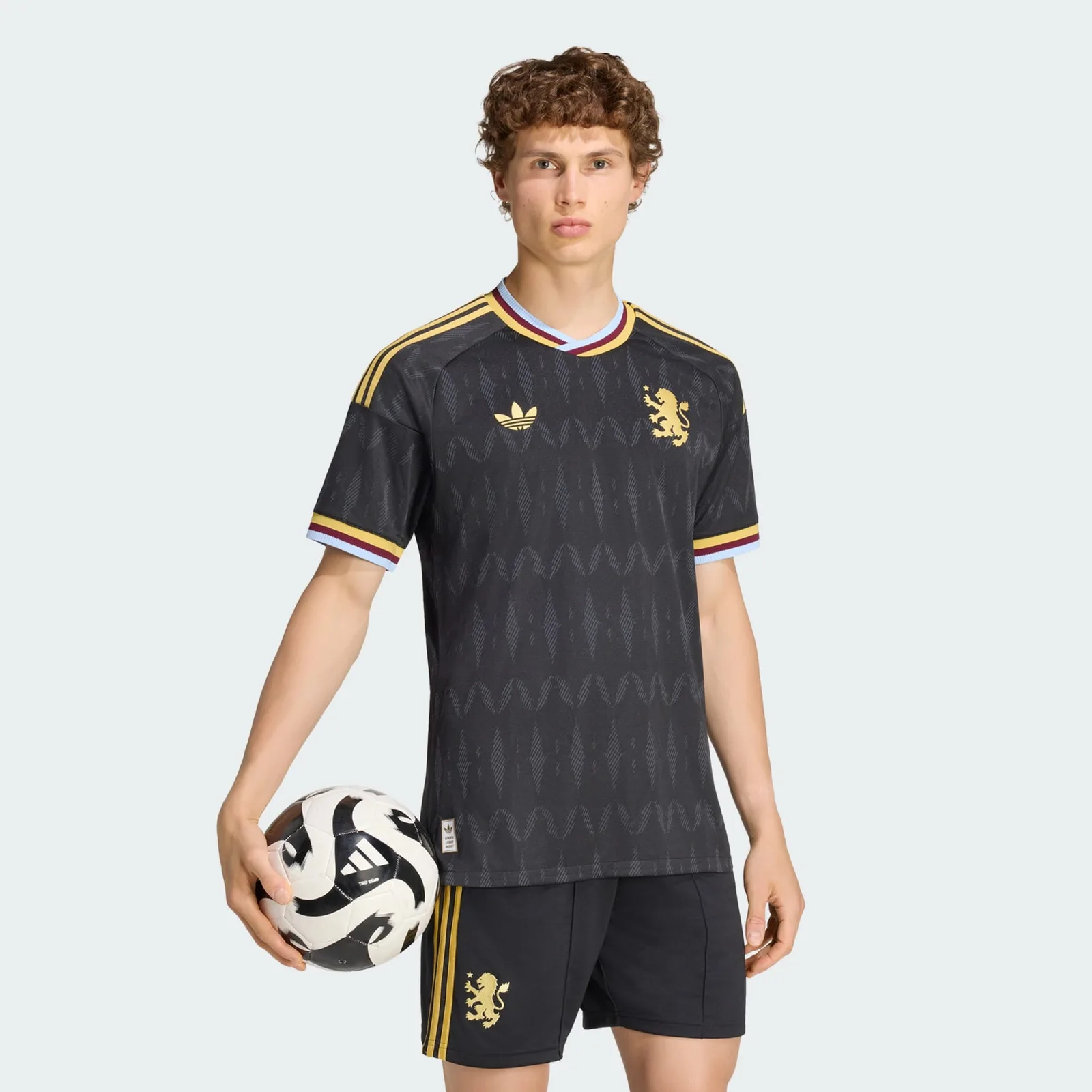 Aston Villa uitshirt 2026/27 — all-zwart met subtiele gaslampen, gouden adidas Originals Trefoil en de leeuw-ster badge van 1982